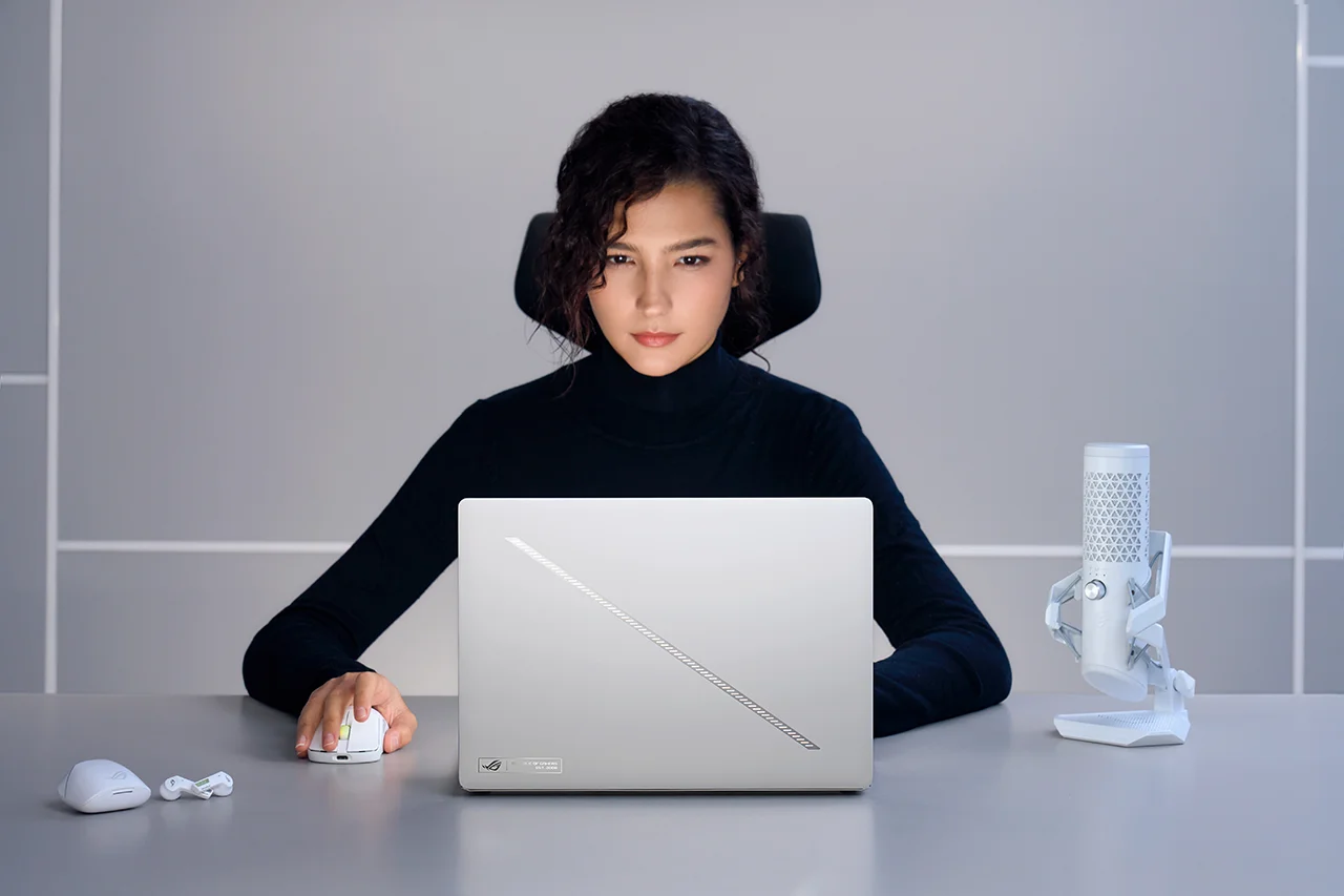 A young podcast host working away on the ASUS Rog Zephyrus laptop in a minimalist setup, highlighting its sleek ROG design and creator-focused accessories.