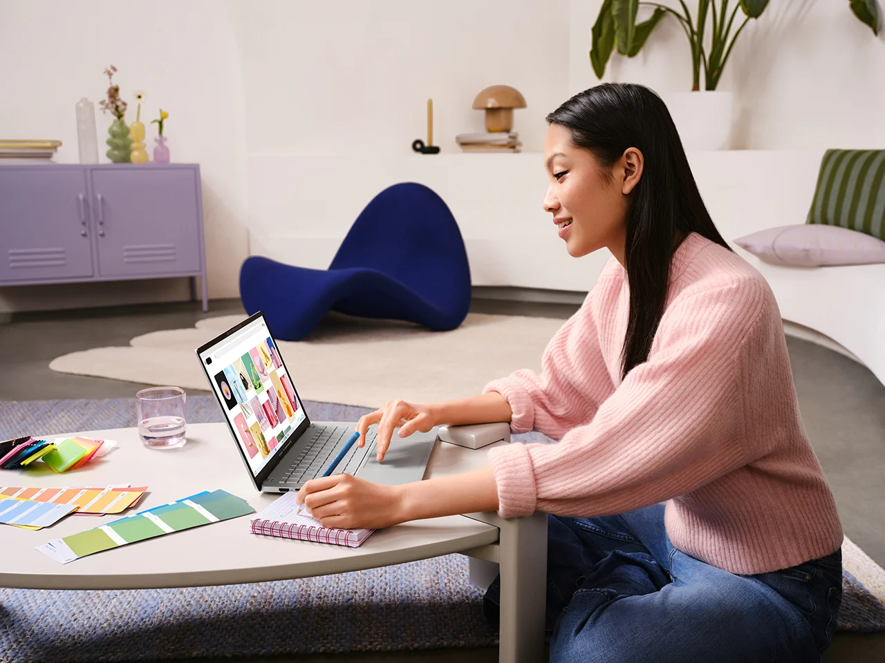 A young person in a creative workspace using an ASUS Vivobook laptop , highlighting its vibrant display and design-focused setup.