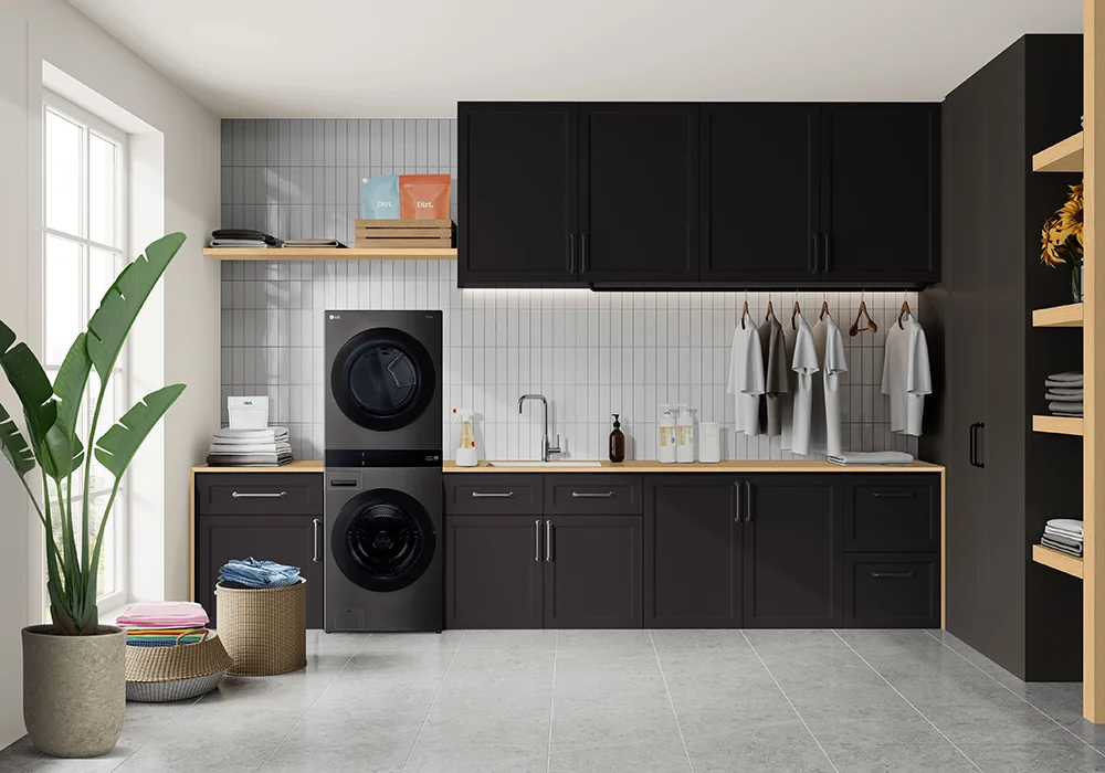 An LG WashTower in a stylish laundry room with black cabinets, wooden counters, detergent bottles, and neatly folded laundry in baskets on the floor.