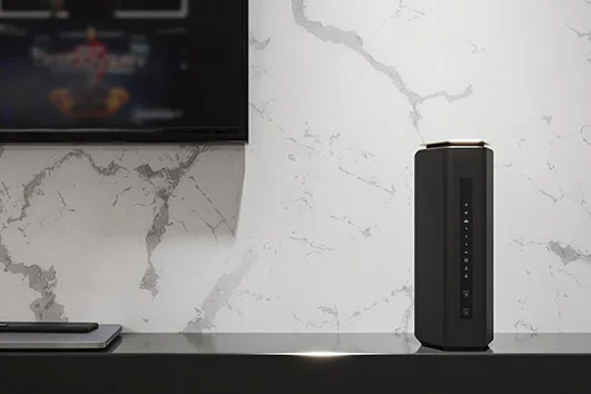 A Nighthawk WiFi 7 router sitting on a shelf in a modern living room.