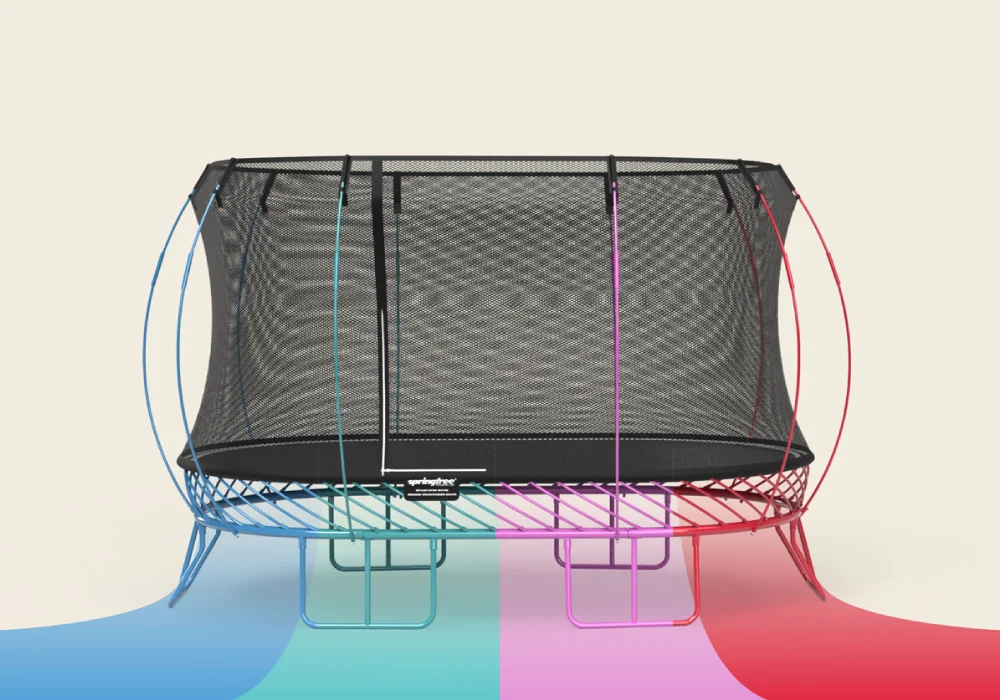 Springfree trampoline with black net enclosure and colorful frame in blue, green, purple, and red.