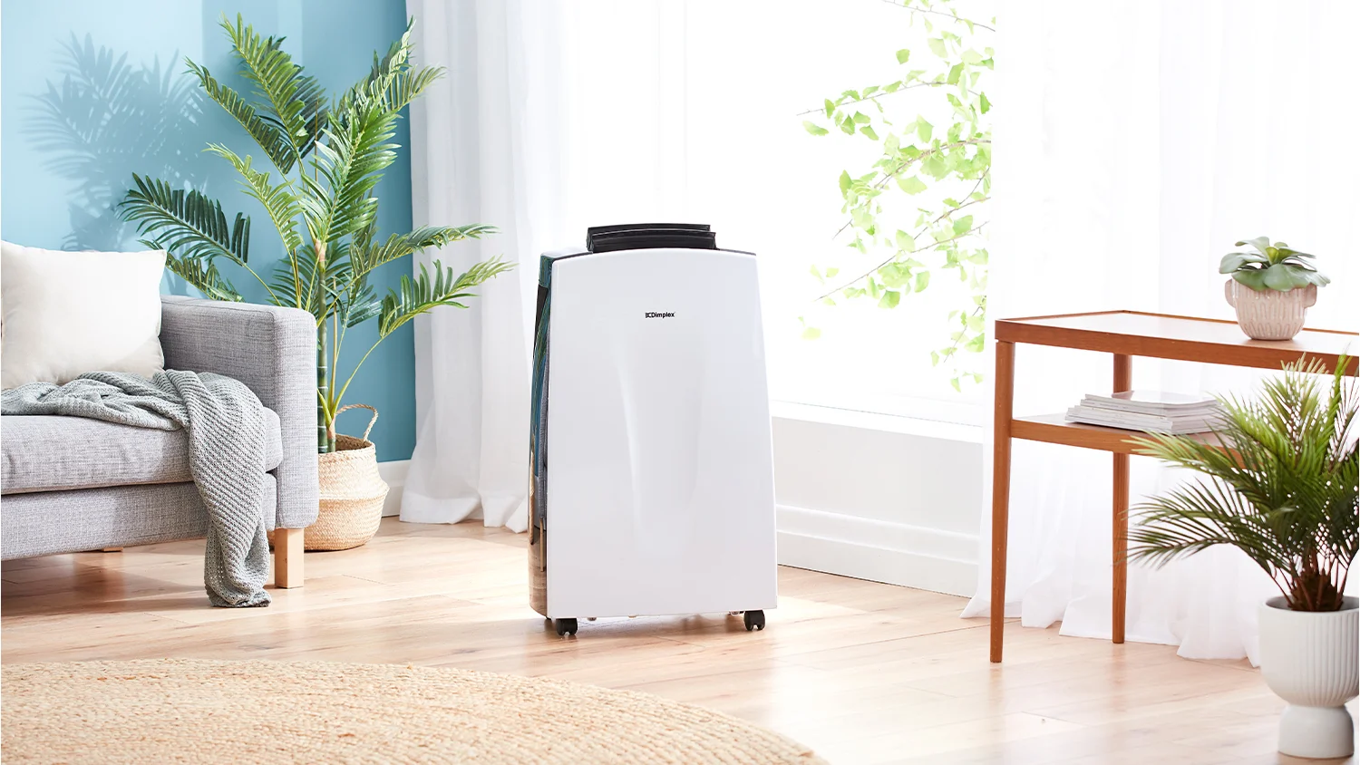 The Dimplex portable air conditioner and dehumidifier running next to a big window in a bright living room.