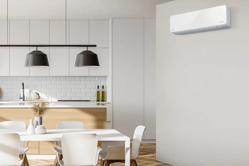 A Fujitsu Comfort Range heat pump on the wall in a modern kitchen/dining area.