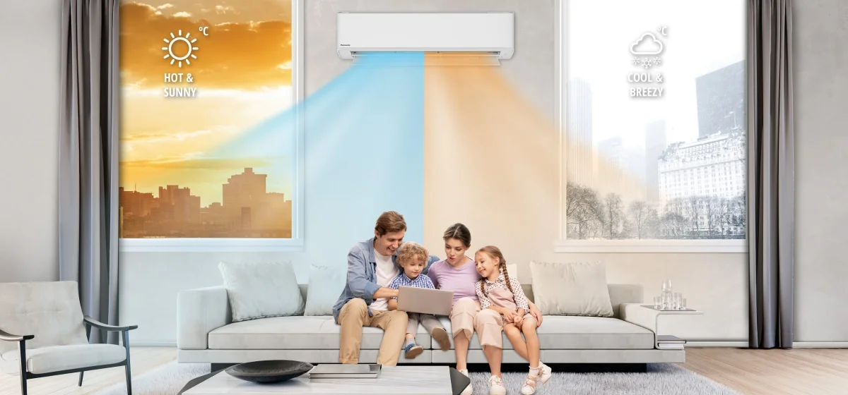 A family of 4 relaxing in the lounge with a Panasonic high wall heat pump running behind them. The cooling and heating airflows are shown in blue and orange.