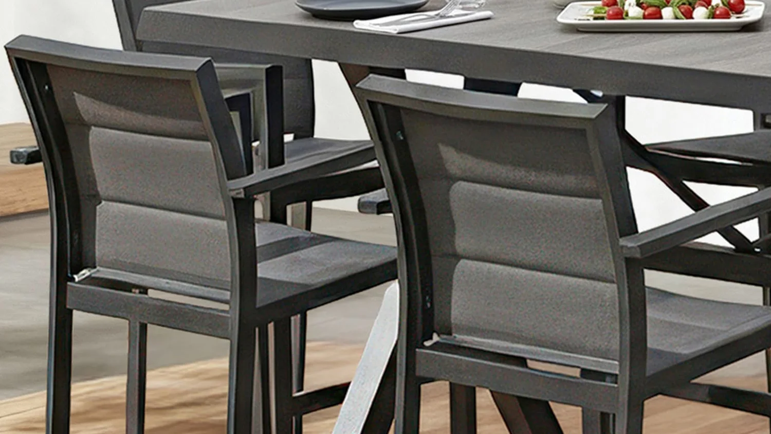 Close up of the backrest of the Bali outdoor bar chair with dark metal frame and Textilene seats.