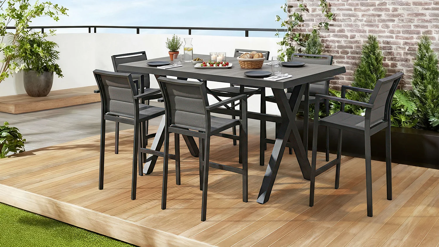 The Bali 7-piece outdoor bar setting with grey slatted high-top table and cushioned chairs on a patio overlooking water views.