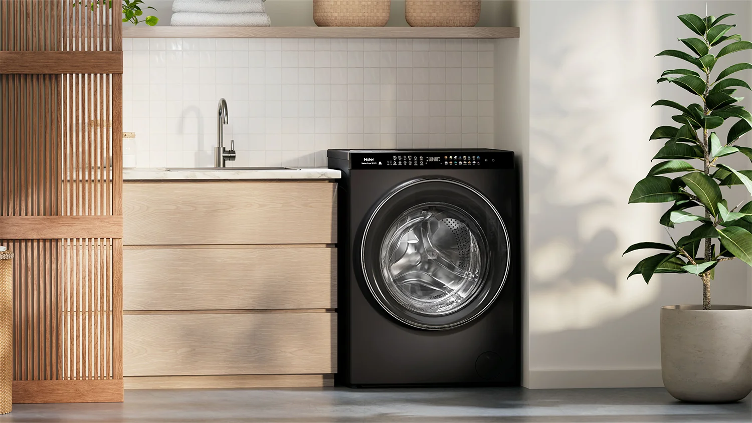 Clean laundry room with an LG top load washing machine between a white counter, a wooden chair on the right and a pot plant. Towels and containers are neatly placed, and the white walls make the room look bright.