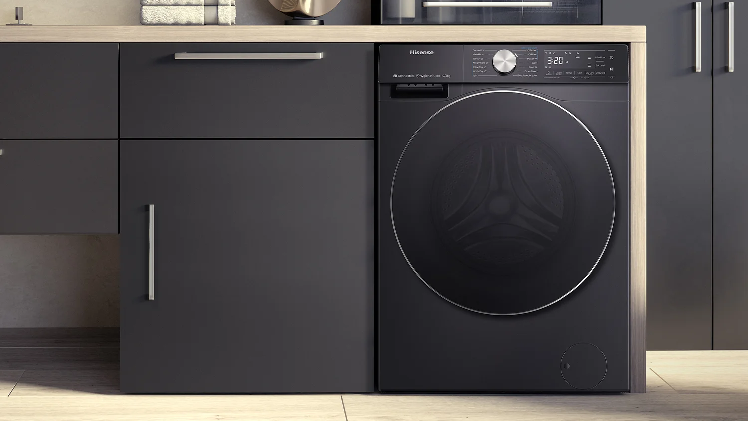 Modern laundry room featuring a black Hisense washing machine integrated into dark grey cabinetry. The machine has a digital display and control knob showing various settings, with the screen reading “3:20” and icons indicating different functions.